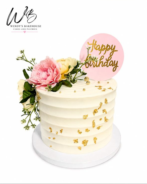 Custom ivory cake with pink flowers and gold details